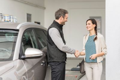 A Hyundai representative shaking hands with a customer.