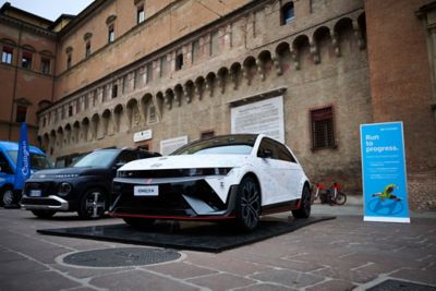 Hyundai mechanic inspecting the underside of a vehicle near the tire.