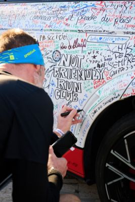 Hyundai mechanic inspecting the underside of a vehicle near the tire.