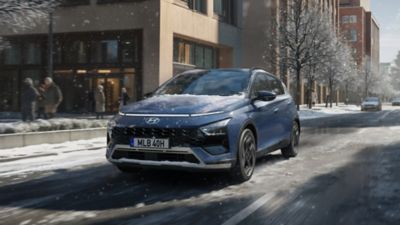 Blå Hyundai BAYON under körning på snöig gata i st