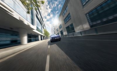 The Hyundai KONA Electric pictured from the front driving along a road