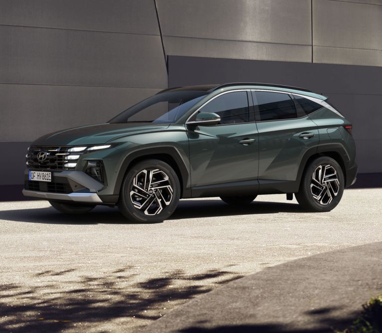 Zelený Hyundai TUCSON Hybrid jazdiaci v meste