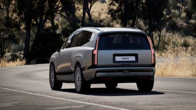 Achteraanzicht Hyundai IONIQ 9 rijdend op een geasfalteerde weg.