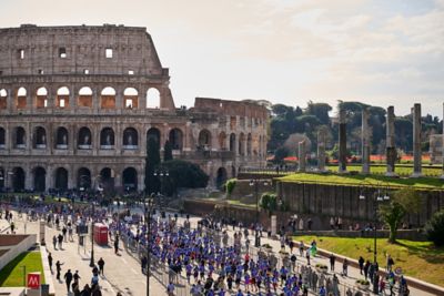 Hyundai mechanic inspecting the underside of a vehicle near the tire.