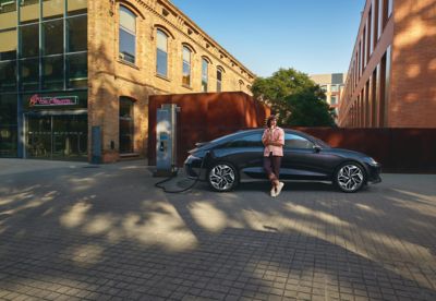 A man plugging in the charging cable for a Hyundai IONIQ.