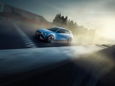 The all-electric Hyundai IONIQ 5 N driving on a race track with some trees in the background.