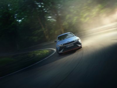 Front view of the all-electric Hyundai IONIQ 5 N driving through a curve.