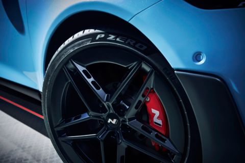 Wheel detail with black alloy rim featuring angular aero-inspired design.