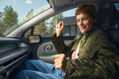 En blid dame i forsetet på IONIQ 9. Foto.