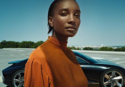 Une femme debout devant un concept car Hyundai 100% électrique garé de profil.