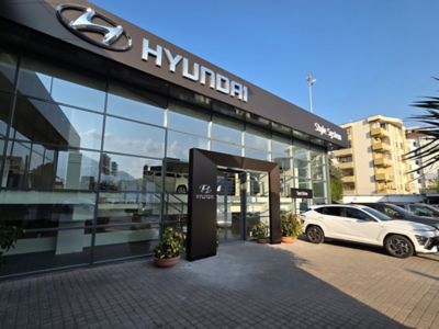 Donna carica un modello Hyundai aiutata da un'assistente Hyundai