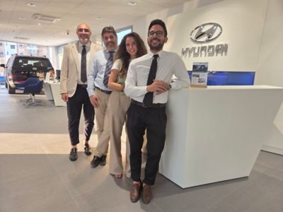 Donna carica un modello Hyundai aiutata da un'assistente Hyundai