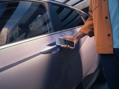 Hyundai KONA Electric SUV parking backwards in a garage between two cars.