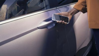 Hyundai KONA Electric SUV beim rückwärts Einparken in einer Garage zwischen zwei Autos.