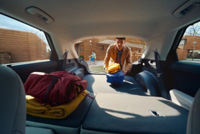 A man loads the trunk of his Hyundai IONIQ 5 with folded rear seats.