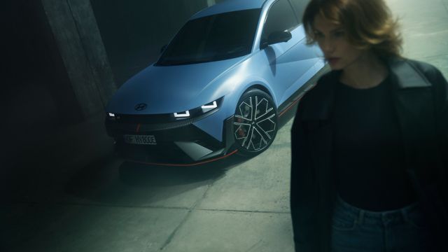 En dame passerer en parkert IONIQ 5 N. Foto.
