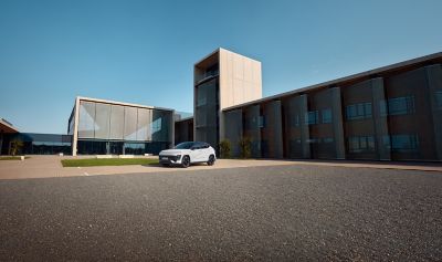 KONA Electric parkert ved et moderne bygg. Foto.