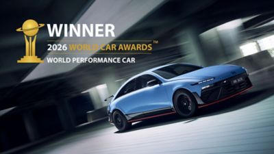 La Hyundai IONIQ 6N traverse une structure moderne, mettant en valeur son agilité et ses performances.