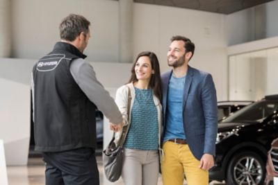 A Hyundai representative greets a couple.