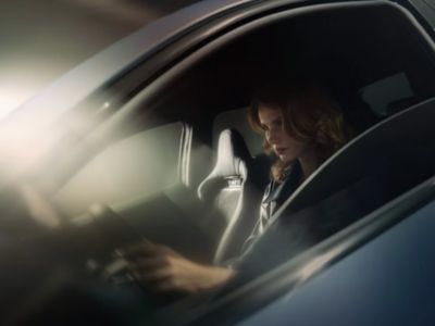 Zicht op vrouw achter stuur via geopend bestuurdersraam.