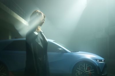 Une femme se promène à côté de IONIQ 5 N high-performance EV.