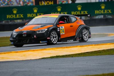  A picture of Hyundai Motorsport’s i30 Veloster N TCR in action on a racetrack shown from the side.
