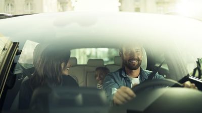 Hyundai i30’un direksiyonunda, dokunmatik ekranı kullanan bir kadın.