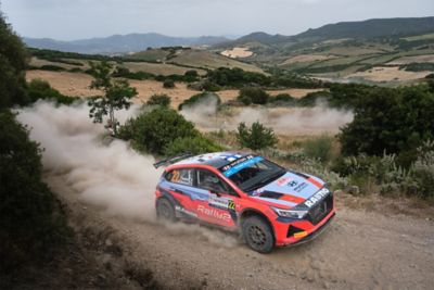 Hyundai Motorsport customer racing a Hyundai i20 N Rally2 on a dirt road.