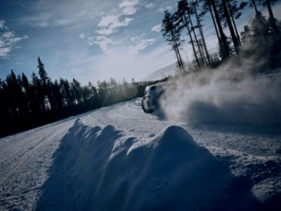 The all-new Hyundai IONIQ 5 N drifting through a snowy curve on a forest road.