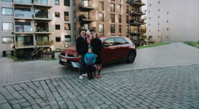 En blid famile poserer foran en IONIQ 5. Foto.