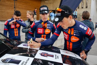Arctic Race of Norway 2025 – Syklister signerer på en Hyundai følgebil. Foto.