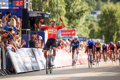 Arctic Race of Norway 2025 – Målgang og første syklist hever armene i været. Foto.