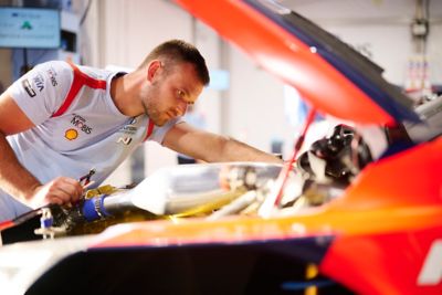 Ein Mechaniker des Hyundai WRC Ralley-Teams arbeitet am Motor eines Hyundai i20 N Rally1.