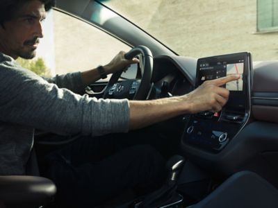 En mann som bruker en berøringsskjermen i en Hyundai. Foto.