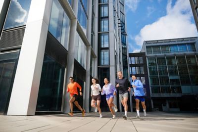 Hyundai mechanic inspecting the underside of a vehicle near the tire.