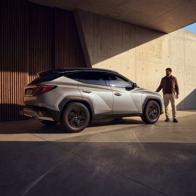 Hyundai TUCSON jazdiaci po mestskej ulici s viditeľnými modernými budovami.