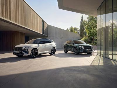 Hyundai TUCSON jazdiaci po mestskej ulici s viditeľnými modernými budovami.