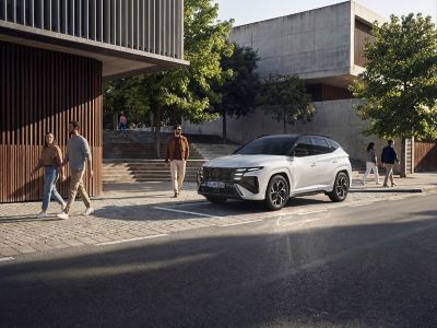Hyundai TUCSON zaparkovaný pred veľkým domom.
