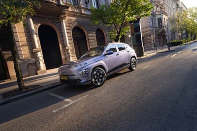 De Hyundai KONA Electric staat geparkeerd voor een traditioneel Europees gebouw.