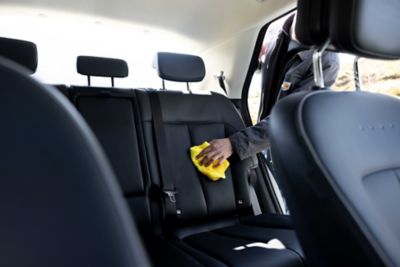 En mann vasker baksetene i en IONIQ 5. Foto.