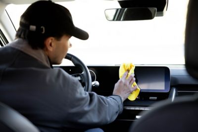 En mann vasker instrumentpanelet i en IONIQ 5. Foto.