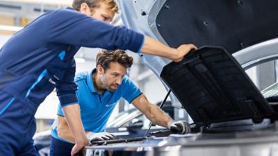 Mechanicy otwierający maskę samochodu