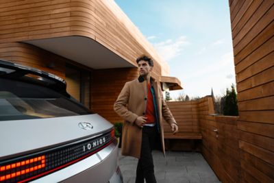 A man standing next to the tail of the Hyundai IONIQ 5 electric vehicle.