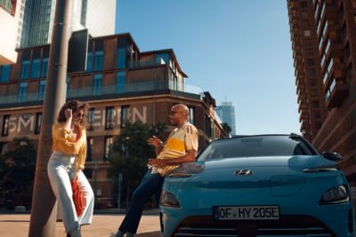 A couple hanging out next to their Hyundai KONA Electric.