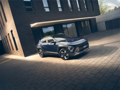 The all-new Hyundai KONA in blue parked next to a men with yellow shirt.