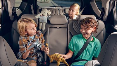 Dwoje dzieci bawi się z tyłu nowego 7-miejscowego SUV-a Hyundai Santa Fe Plug-in Hybrid.