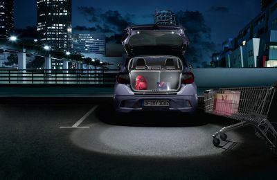 The Hyundai i10 boot open with two bags inside.