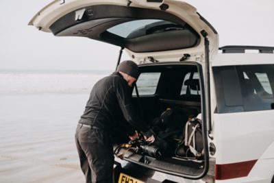 A man loading the Hyundai Santa Fe via its large tailgate opening. 