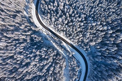 Straße im Winterwald aus der Vogelperspektive