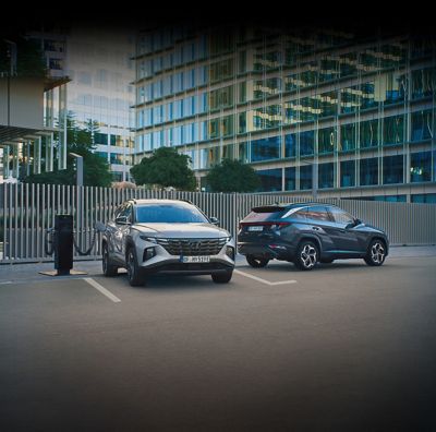Nuevo Hyundai TUCSON Híbrido Enchufable aparcado frente a una casa con una familia.